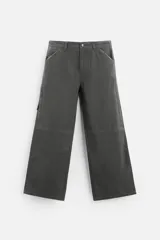 Pantalón gris oscuro de corte amplio, con bolsillos frontales y traseros de parche. Incluye un bolsillo lateral con cierre de cremallera.