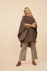 Poncho unisex de lana color marrón con cuello alto y broche a presión. Diseño exclusivo de Don Baez, hecho en Uruguay.