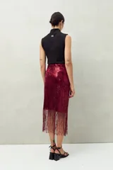 Falda larga de lentejuelas color borgoña con terminación en flecos.