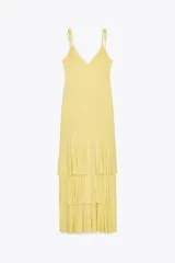 Vestido midi amarillo pálido con tirantes finos ajustables y escote en pico. Falda con tres volantes en capas.
