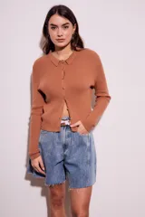 Cardigan negro de punto con cuello polo, manga larga y cierre frontal con botones.