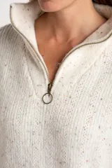 Sweater de tejido de punto color blanco roto, con motas de colores (efecto tweed o confetti), cuello alto con cierre metálico parcial y calce oversize.