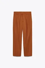Pantalón color marrón confeccionado en hilatura con mezcla de lyocell y algodón. Tiro medio, cintura con trabillas, bolsillos laterales, pinzas en delantero y raya planchada. Cierre frontal con cremallera, botón y ganchos metálicos.