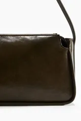 Cartera bandolera de cuero color verde oliva, con correa fina ajustable y cierre superior. Interior forrado.