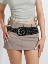 Cinto negro de cuero sintético con hebilla plateada y ojalillos metálicos.