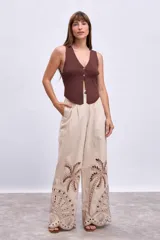 Chaleco de tejido de punto acanalado color marrón oscuro, con escote en V y cierre frontal con botones dorados.