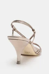 Sandalia de tacón fino color dorado, con tiras finas cruzadas en el empeine y tobillo.