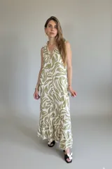 Vestido largo camisero sin mangas, con estampado de hojas en verde y blanco, cuello camisero y cierre frontal con botones.