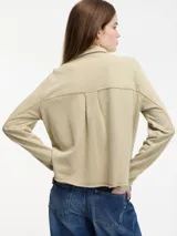 Sobrecamisa gris con broches metálicos en la parte delantera, bolsillo con solapa y cuello camisero.