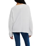 Camiseta blanca de punto waffle en algodón, con silueta relajada, hombros caídos, mangas largas, bolsillo frontal y escote amplio tipo barco.