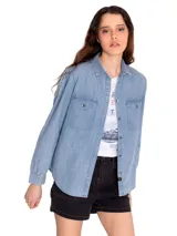 Camisa de manga larga celeste de denim con dos bolsillos en el pecho y cierre con botones metálicos.