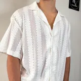 Camisa negra tejida con cuello solapa, manga corta y corte oversize.
