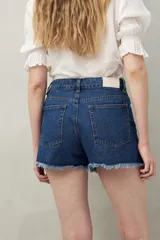 Short de jean azul con bordado floral en el frente y ruedo desflecado.