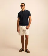 Bermuda de sarga de algodón color blanco, con cintura fija, pasadores para cinturón, cierre tradicional y bolsillos funcionales.