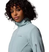 Polar de mujer Columbia, color azul claro, con cierre frontal completo, cuello alto y bolsillos laterales con cremallera. Presenta un bolsillo con cremallera en la manga izquierda y costuras horizontales a la altura del pecho.