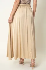 Pollera larga color beige de satén de seda, de corte amplio, con cintura elastizada y lazo.