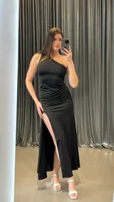 Vestido largo negro de un solo hombro con abertura lateral en la pierna.