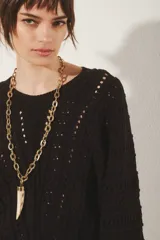 Sweater tejido de algodón color negro, con diseño de ochos y puntos calados, escote redondo y manga larga.