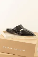 Sandalias tipo mule de cuero marrón con puntera cuadrada, diseño abierto y hebilla ajustable.