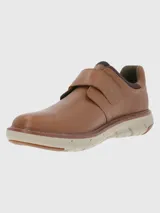 Zapato marrón de cuero con ajuste de velcro y suela gruesa color crema.