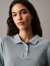 Chomba celeste de punto de algodón suave, corte slim, cuello de chomba, tapeta de tres botones, mangas cortas y bordado de Calvin Klein en la misma gama de tonos en el pecho.