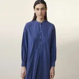 Vestido largo azul a rayas verticales, con cuello mao, mangas largas y corte evasé.