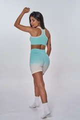 Conjunto deportivo de top y short color verde agua con degradé a blanco. El top es de corte racer-back y tiene el logo "bk." estampado en el frente. El short es de tiro alto.