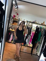 Vestido corto negro con escote halter atado al cuello.