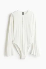 Body blanco de punto acanalado, con escote redondo, tapeta de botones y mangas largas acampanadas.
