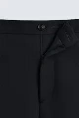 Pantalón de vestir negro slim fit confeccionado en tejido de lana de origen italiano. Cuenta con bolsillos frontales y traseros de vivo con botón. Cierre frontal con cremallera y botón. Colección especial Origins.