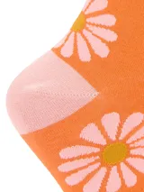 Calcetines altos color naranja con estampado de margaritas blancas y centro amarillo. Puño, talón y puntera en color rosa. Confeccionados en fibra de bambú.