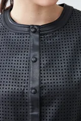 Chaqueta negra de eco cuero calado, con cuello redondo y cierre frontal con botones a presión.