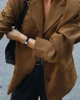 Blazer de gamuza color camel, con solapas de muesca, cierre con dos botones, bolsillos laterales con solapa y forro interior.