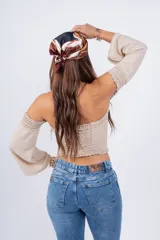 Top color beige, con escote off-shoulder con elástico y mangas largas acampanadas.