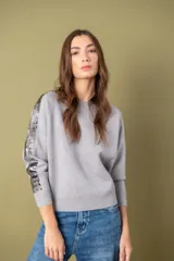 Sweater negro de dama con lentejuelas en las mangas y corte holgado.