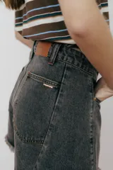 Short de jean de tiro alto, color negro lavado, con corte ancho y dobladillo deshilachado.