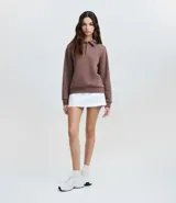 Saco femenino cerrado de algodón con felpa más sostenible, color beige. Presenta cuello polo con abotonado parcial, manga larga y bajo ajustado.