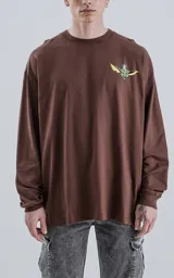 Remera de manga larga color marrón con cuello redondo y estampado pequeño de un gremlin en el pecho.