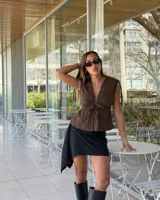 Blusa verde con rayas blancas, fruncida con ataduras en el frente y en los hombros.