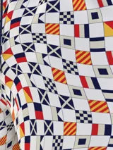 Short de baño blanco con estampado de banderas náuticas en azul, rojo y amarillo. Tiene cintura elástica con cordón ajustable, bolsillos laterales y logo de Tommy Jeans en la pierna.