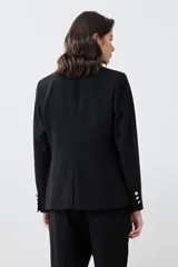 Blazer negro de corte clásico con solapas de muesca, cierre frontal con un botón y bolsillos con solapa.