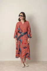 Vestido largo de lino color verde militar con estampado de hojas en tonos azul, naranja y marrón. Tiene cuello mao con botones, mangas tres cuartos y un bolsillo en el pecho.