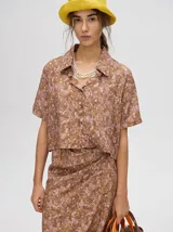 Vestido largo color marrón con estampado floral, escote en V, tirantes finos y abertura lateral.