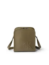 Cartera tipo reporter de piel sintética color verde oliva, con correa ajustable para llevar cruzada. Presenta el monograma 'CK' grabado en relieve en el frente, cierre de cremallera superior, bolsillo abierto trasero y tarjetero interior.