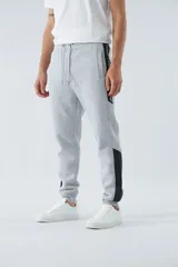 Pantalón de jogging gris oscuro de felpa con puños, cintura ajustable con cordón y logo estampado en la pierna.