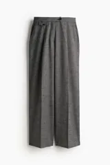 Pantalón sastrero gris con cintura elástica de tiro alto, cierre y pretina prolongada con botón. Modelo con bolsillos al bies, solapa decorativa con botón adelante y bolsillos de atrás insertados. Piernas amplias con pinzas y pliegues adelante y atrás.