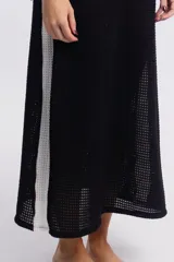 Vestido largo de tejido calado color negro, con breteles finos y corte recto con aberturas laterales.