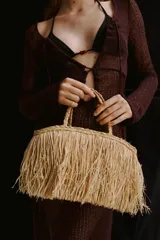 Bolso de mano tipo shopper confeccionado en paja de papel color natural con efecto desflecado. Tiene dos asas trenzadas y no está forrado.