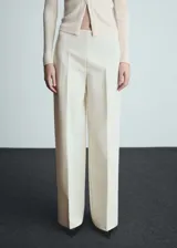 Pantalón de vestir color crema, de tiro medio y corte wide leg.