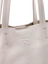 Cartera shopper de cuero color crudo, con terminaciones al corte y bolsillo interior con cierre.